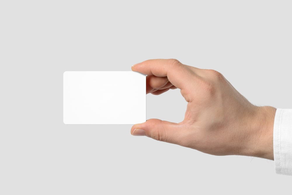 Image of a person’s hand holding a blank business card with rounded corners